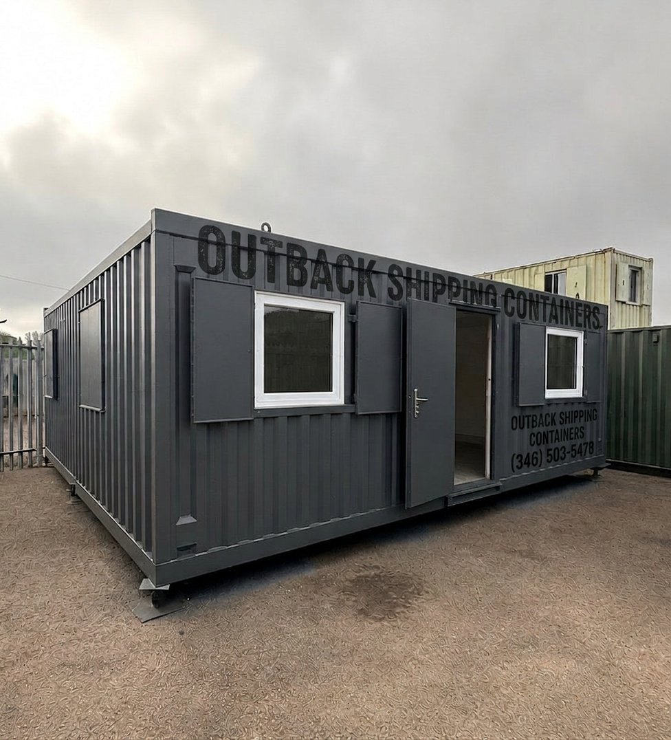 Refurbished gray modular shipping container building with windows and open door