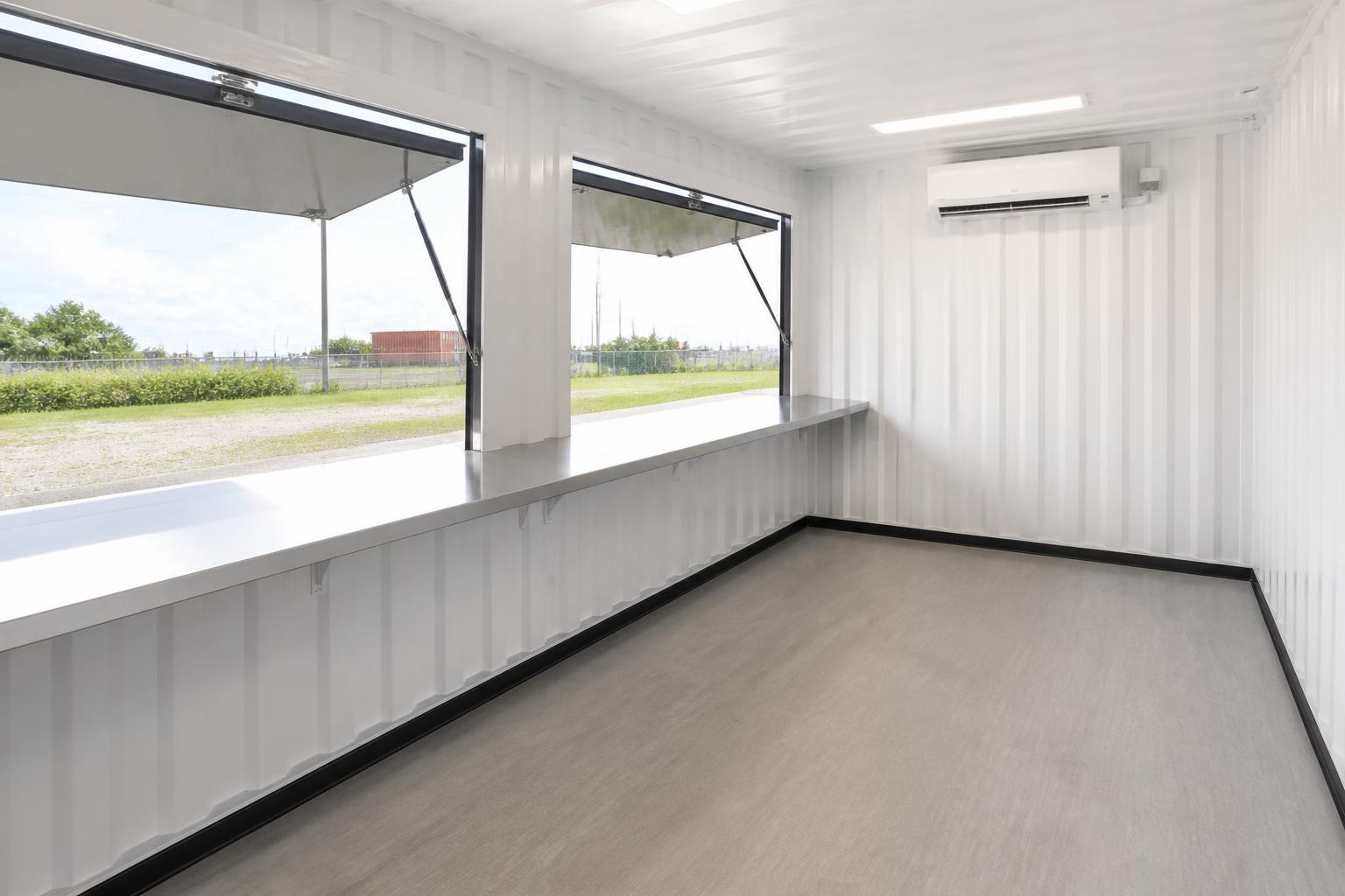 Interior service counter of the concession kiosk in stainless steel beneath the open serving hatches