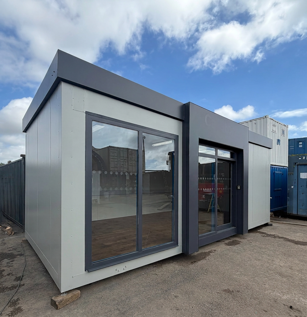26x12ft for Sale — Front Exterior View | Outback Shipping Containers Modern 26x12ft marketing suite featuring large glass windows and grey exterior panels under a blue sky