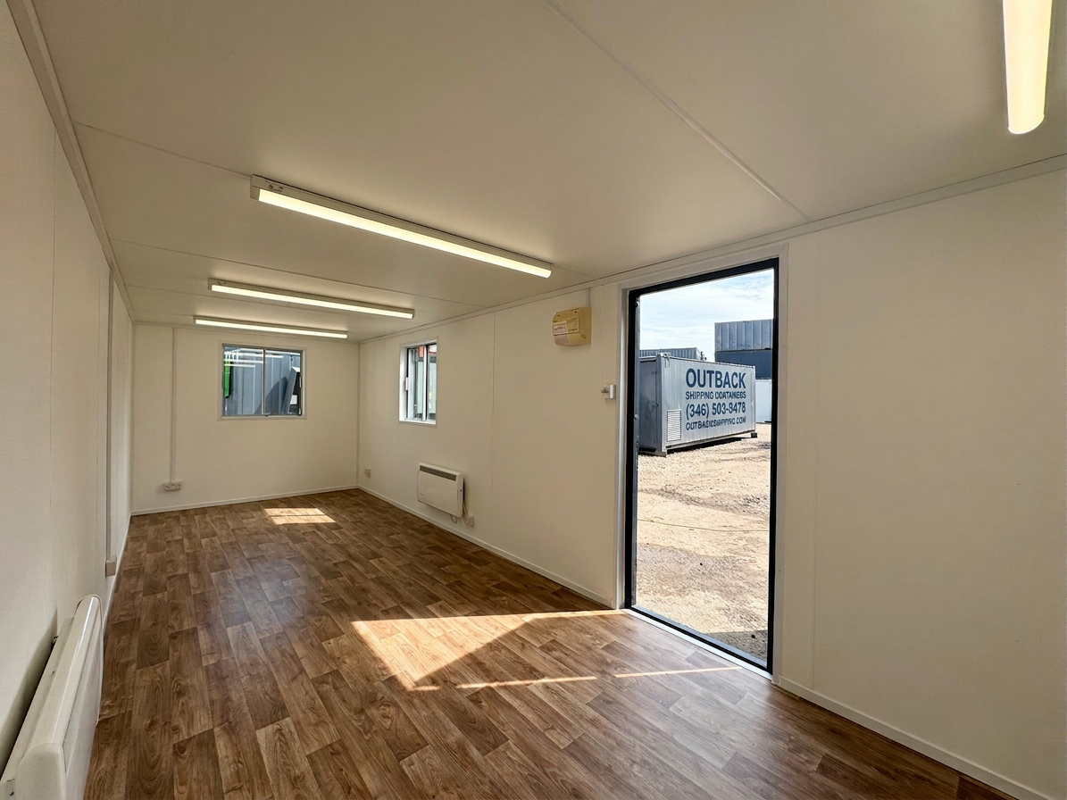Interior view of a 24x9 open plan office cabin with wood vinyl flooring white walls and overhead LED tube lighting